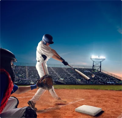 Baseball batter swinging a bat at home plate during baseball injury rehab and throwing mechanics training.